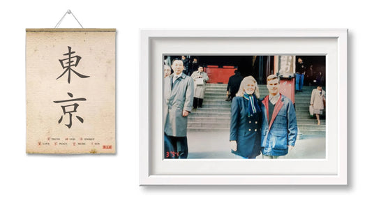 Wandbild mit japanischem Schriftzeichen und gerahmtes Foto von Personen vor einem Gebäude